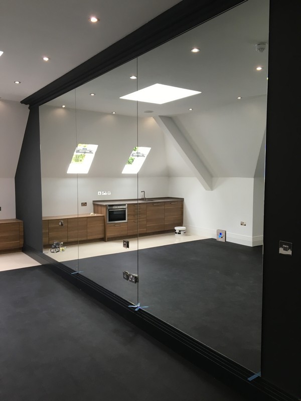 Frameless glass partition in loft conversion by Olney glaziers