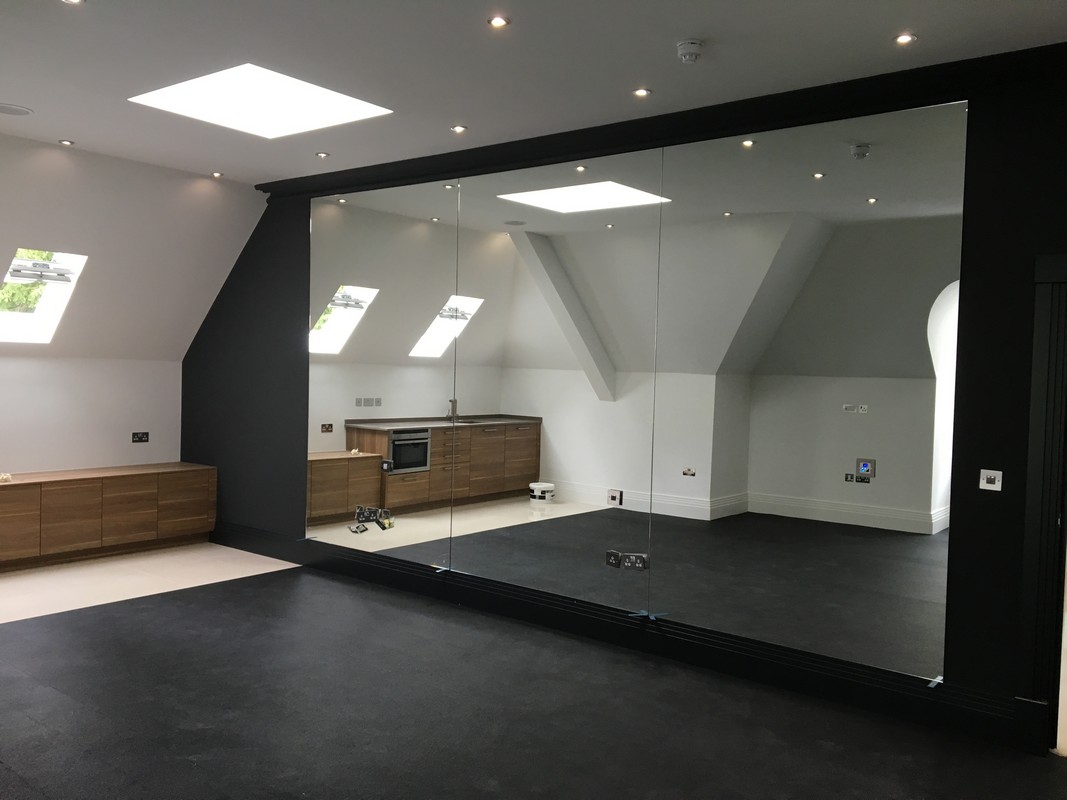 Frameless glass wall dividing loft conversion in Olney